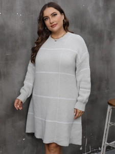 Detail of light gray knit dress featuring large white grid patterns and ribbed cuffs