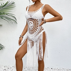 Détail de la robe de plage crochetée blanche avec motifs circulaires et longues franges