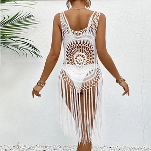 Détail d'une robe de plage en crochet blanc avec motif mandala au dos et franges