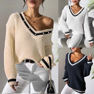 Detail of V-neck knitted sweater featuring contrast striped trim and pearl button accents