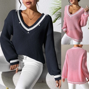 Close-up of V-neck knitted sweater with contrast stripes and pearl button details