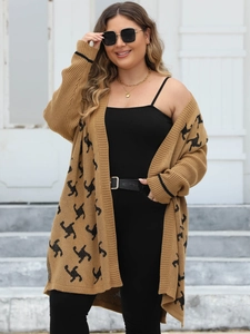 Dettaglio ravvicinato del cardigan in maglia con motivi astratti neri su tessuto cammello