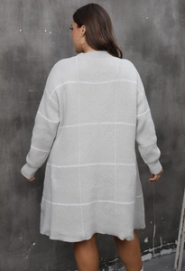 Back view of a long grey knitted cardigan with large white plaid pattern and long sleeves