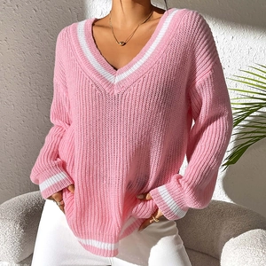 Detail of V-neck pink knit sweater with white striped ribbed cuffs and collar texture