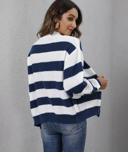 Texture dettagliata della maglia di un cardigan a righe blu e bianche con bottoni