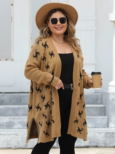 Dettaglio di un lungo cardigan in maglia marrone con motivi geometrici neri e spacchi