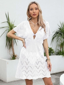 Close-up of white crochet beach dress featuring geometric hollow textures and V-neckline