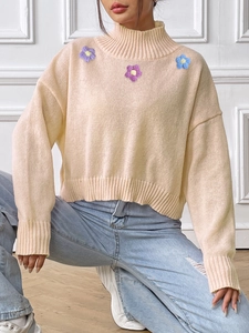 Detail of floral embroidery on high neck beige knit sweater for women stylish knitwear