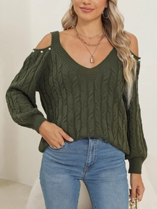 Detail of dark green knit sweater with cold shoulder design and pearl button accents