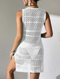 Detailansicht eines weißen Häkel-Strandkleides mit Lochmuster-Textur und hohem Seitenschlitz