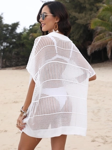 Détail du motif en maille crochet ajourée sur une chemise de plage boho blanche