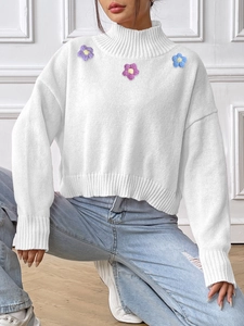 Detail of high neck knit sweater with three 3D crochet floral appliques on the chest