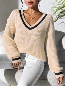 Close-up of V-neck knitted sweater with black stripe details and open-work texture
