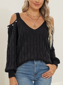 Detail of black cable knit off-shoulder sweater with pearl buttons and deep V-neckline