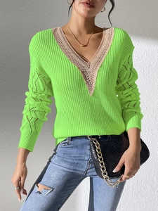 Detail of neon green knit sweater featuring V-neck beige lace trim and hollow out sleeves