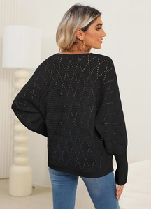 Detail of black hollow-out knit sweater featuring elegant diamond crochet patterns