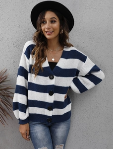 Dettaglio del cardigan in maglia a righe bianche e blu con scollo a V e grandi bottoni