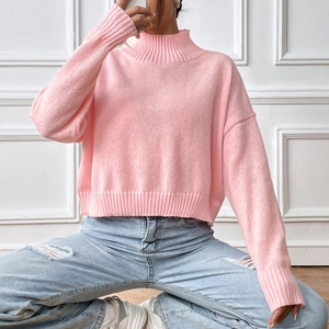 Detail of pink turtleneck sweater showing soft knit texture and ribbed cuffs