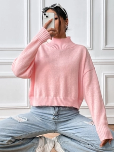 Close-up of pink turtleneck knit sweater with ribbed cuffs and hem on model