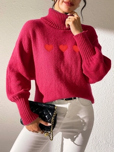 Detail of rose red turtleneck sweater featuring three red heart embroidery and rib cuffs
