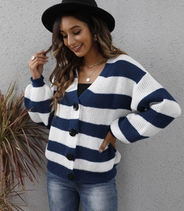 Dettaglio del cardigan a maglia a righe bianche e blu con grandi bottoni neri
