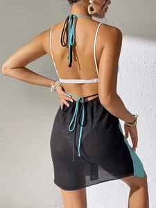 Detail of crochet backless mini dress with contrasting blue trim and tie-up back design