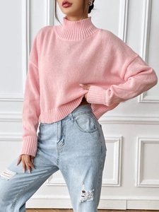 Detail of pink turtleneck knit sweater with ribbed cuffs and hem on casual model