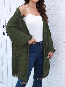 Detail of dark green knit cardigan featuring 3D cable stitch pattern and chunky texture