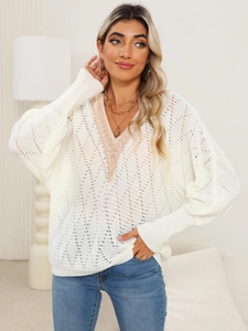 Detail of elegant V-neck lace trim and hollow-out knit texture on a white batwing sweater