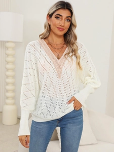 Close-up of white hollow knit sweater with lace V-neck stitching and ribbed cuffs