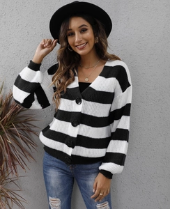Dettaglio cardigan in maglia a righe bianche e nere con grandi bottoni e scollatura a V