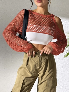 Detail of crochet brick red bolero shrug with intricate hollow knit mesh pattern