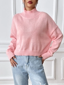 Close-up of pink turtleneck sweater with detailed ribbed cuffs and hem knit texture