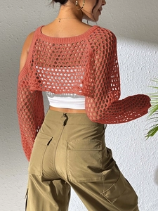 Detail of orange crochet mesh shrug showing loose knit texture and long sleeve design