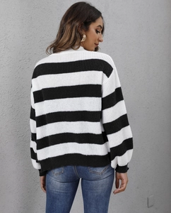Vista posteriore di un cardigan in maglia a righe bianche e nere con bottoni