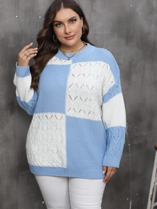 Detail of blue and white color block sweater with cable knit and checkerboard pattern