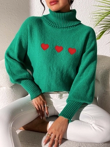 Detail of high neck bright green knit sweater with three red heart embroidery on the chest