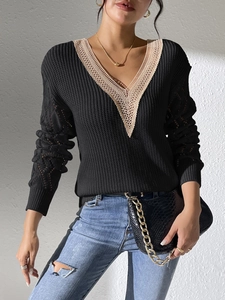 Close-up of black V-neck sweater with skin-tone lace trim and hollow crochet sleeves