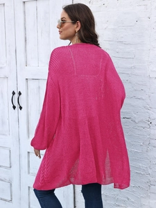 Detail of loose fit knit cardigan in fuchsia pink with back texture and cable sleeve