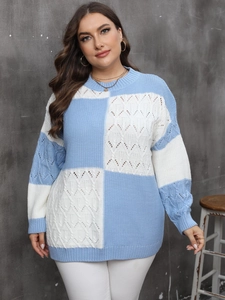 Detail of blue and white plaid sweater showing intricate cable knit textures and patterns