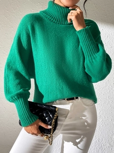Close-up of emerald green turtleneck sweater showing ribbed cuffs and knit texture