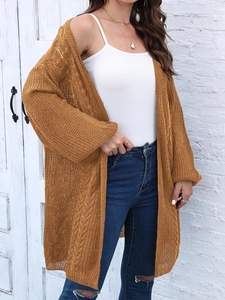Detail of chunky knit texture and retro cable pattern on caramel oversized cardigan