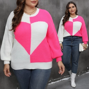 Detail of plus size long sleeve sweater featuring a bold pink and white heart patchwork design