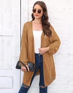 Close-up of mustard yellow cable knit cardigan with lantern sleeves and textured weave