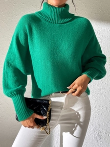 Detail of bright green ribbed turtleneck sweater with drop shoulder and long cuffs