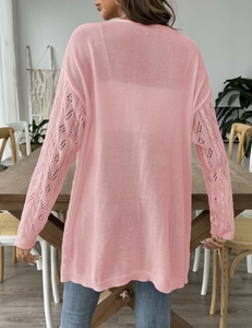 Rear view of pink cardigan featuring diamond knit cut-outs on sleeves and relaxed fit