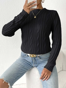 Detailed close-up of a women's black cable knit sweater with a soft textured weave pattern