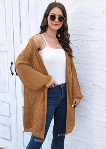 Detail of loose mustard yellow knit cardigan for women with a cozy oversized texture