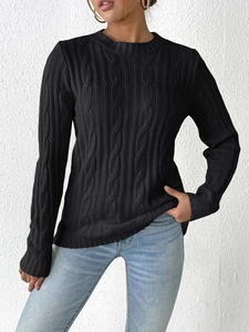 Close-up of black cable knit sweater texture showing detailed ribbed cuffs and round neck