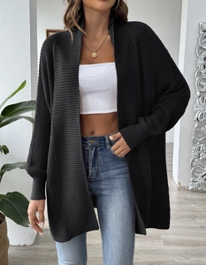 Detailed view of black chunky knit long cardigan with textured weave and ribbed cuffs